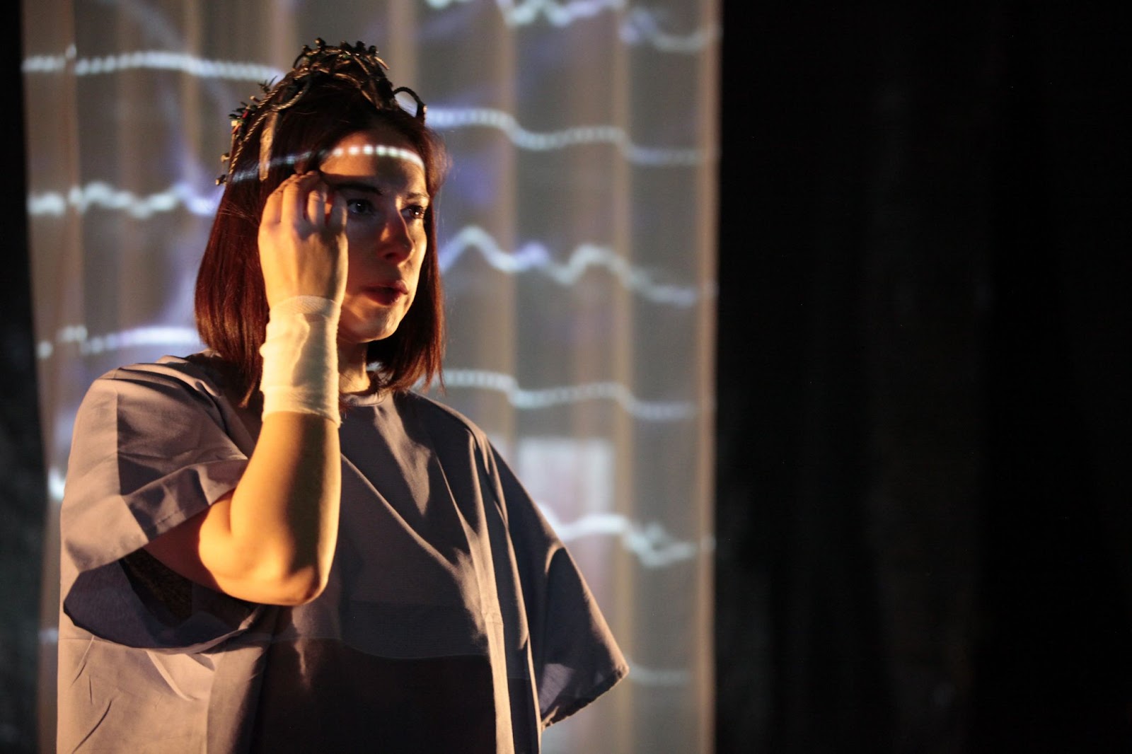 a woman puts her hand to her temple, as a dotted line is projected across her forehead